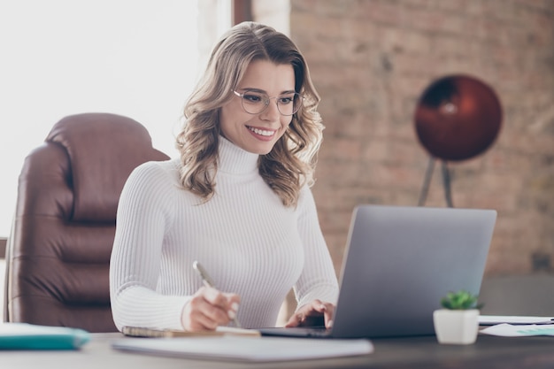 vrouw in haar kantoor die op laptop werkt