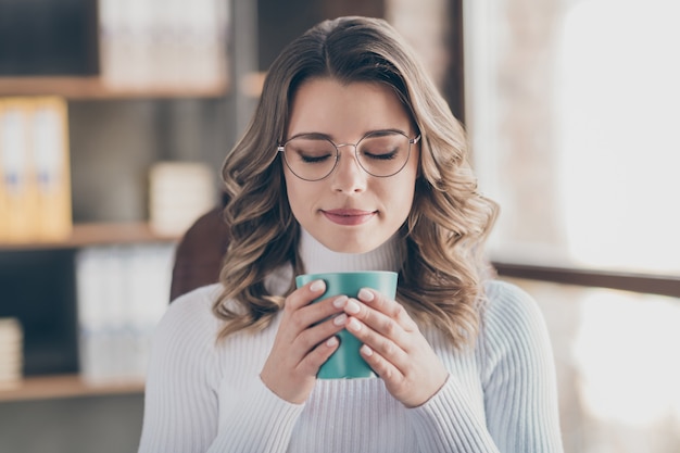 vrouw in haar kantoor koffie drinken