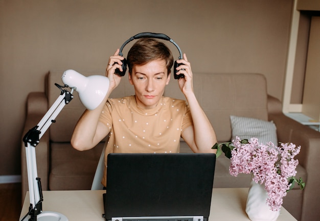 Vrouw in heldere werkende laptop van het huisbureau