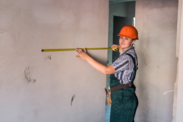 Vrouw in helm en beschermend uniform poseren met meter