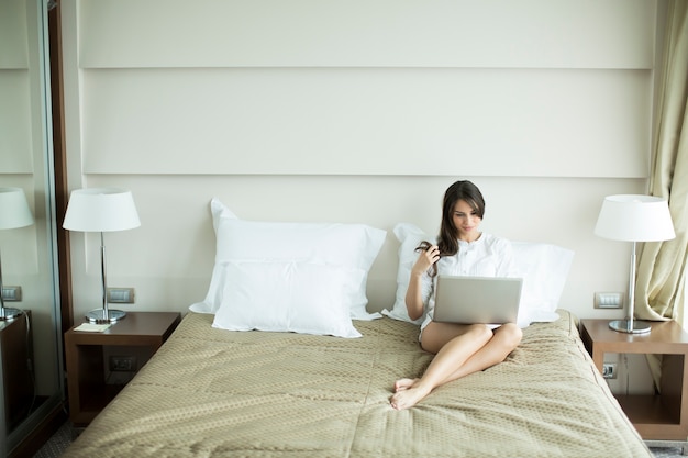 Vrouw in het bed met laptop