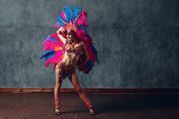 Vrouw in het Braziliaanse kostuum van sambacarnaval met kleurrijk verenkleed.