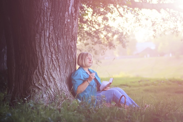 vrouw in het park bij zonsondergang met boek