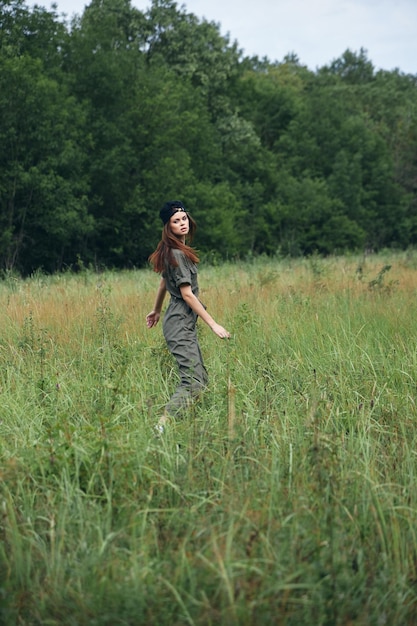 Vrouw in het veld Groene jumpsuit wandeling reizen