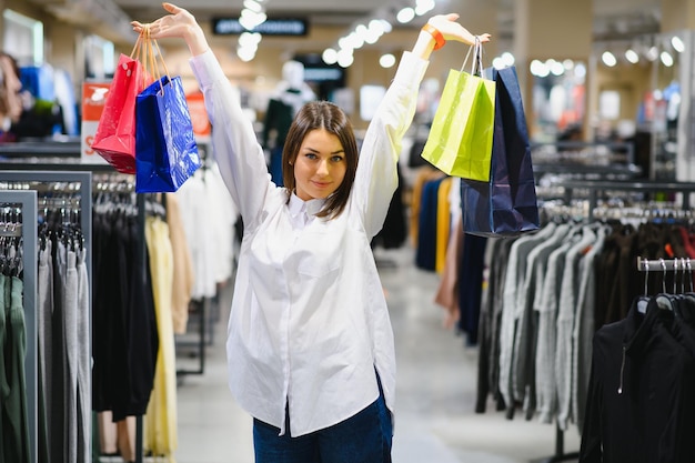 Vrouw in het winkelen. Gelukkige vrouw met boodschappentassen genieten van winkelen. Consumentisme, winkelen, lifestyle concept