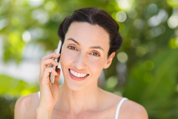 vrouw in het wit met behulp van haar telefoon