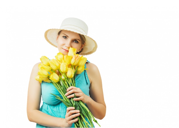 Vrouw in hoed en blauwe jurk met een boeket van geel-rode tulpen geïsoleerd op wit