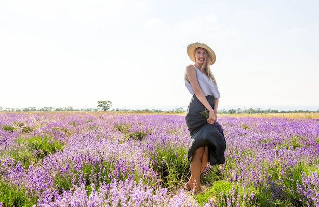 vrouw in hoed en jurk op lavendel veld