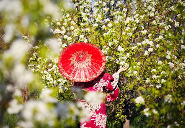 Vrouw in Japans kostuum bij kersenbloesem