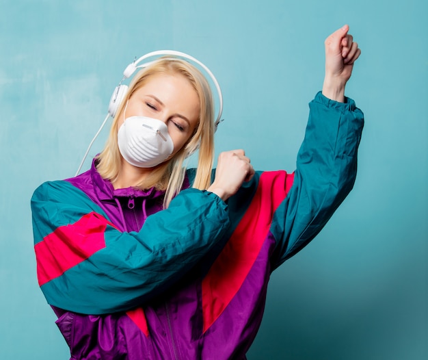 Vrouw in jaren 90 kleding en gezichtsmasker met koptelefoon