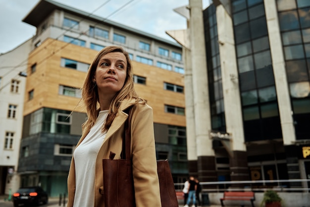 Foto vrouw in jas loopt op straat in de stad