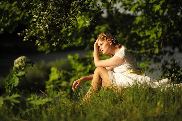 Vrouw in jurk zittend op gras