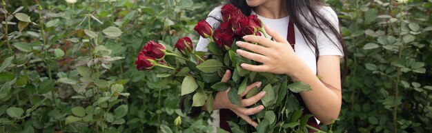 Vrouw in kas met boeket rozen