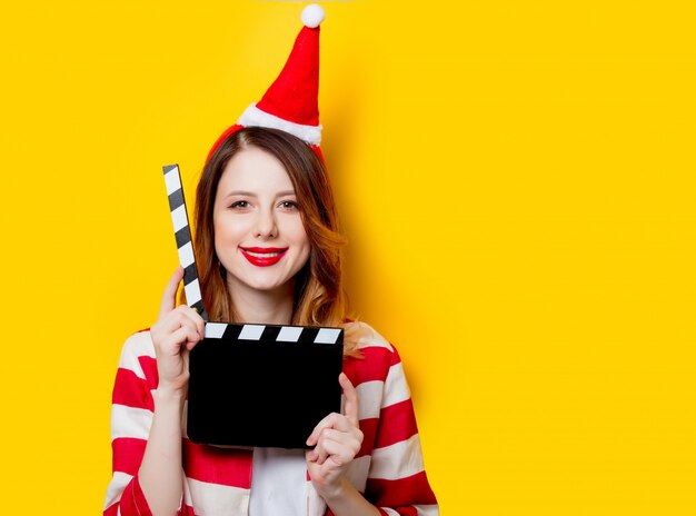 vrouw in kerstman hoed met filmen clapperboard