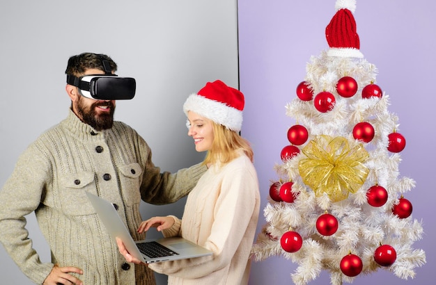 Vrouw in kerstmuts met laptop bebaarde man in virtuele d bril d technologie virtual reality