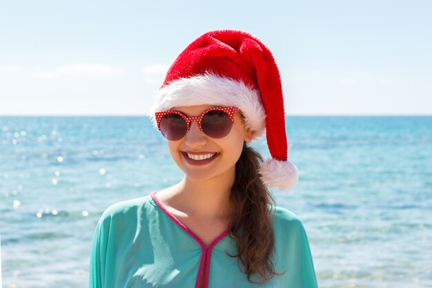 vrouw in kerstmuts op het strand