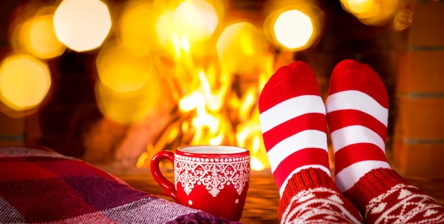 Vrouw in kerstsokken bij open haard