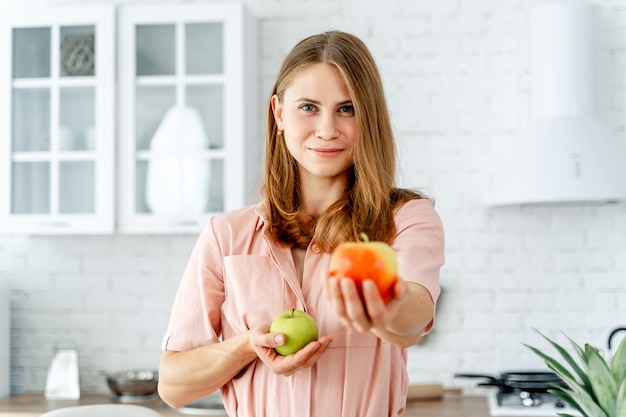 Vrouw in keuken klaar om maaltijd met groenten en fruit voor te bereiden.