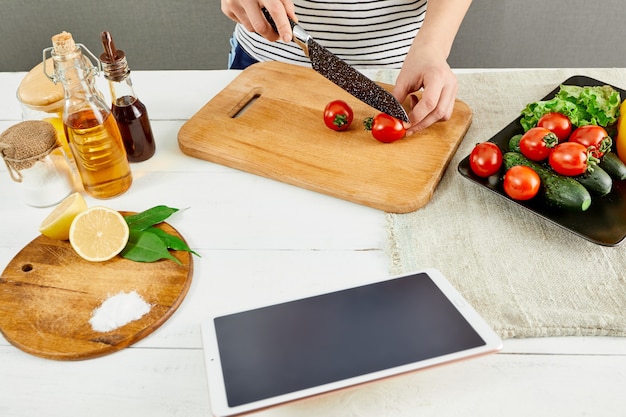 Vrouw in keuken zoekt recept op internet