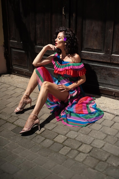 Vrouw in kleurrijke jurk zittend op de grond
