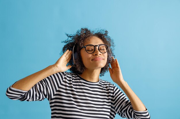 Vrouw in koptelefoon genieten van muziek in studio