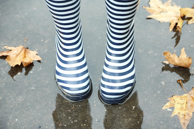 Vrouw in laarzen op regenachtige herfstdag