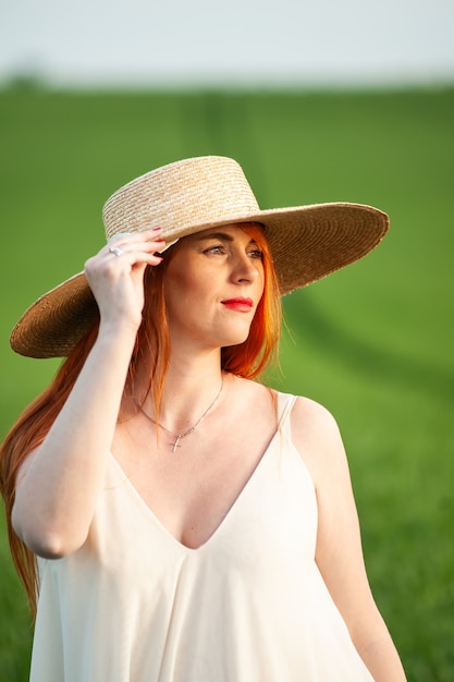 Vrouw in lange witte jurk op een groen veld