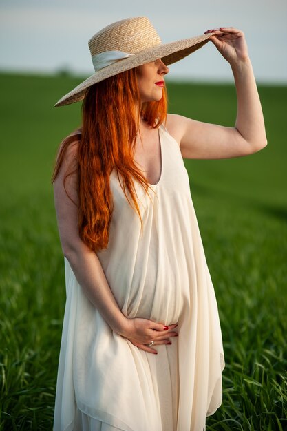 Vrouw in lange witte jurk op een groen veld