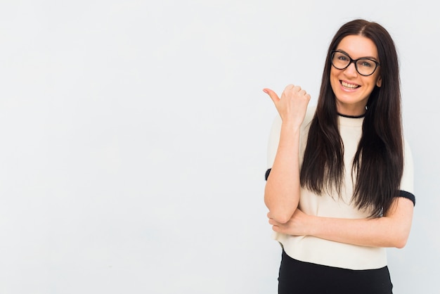 Vrouw in lichte kleren die weg met duim richten