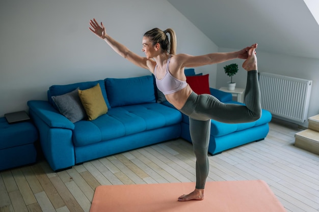 Vrouw in lord of the dance yoga pose training thuis