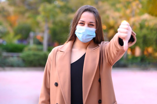 Vrouw in masker met neer duim