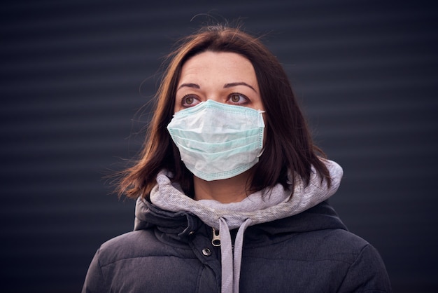 Vrouw in masker op straat omdat epidemie van coronavirus in de stad.