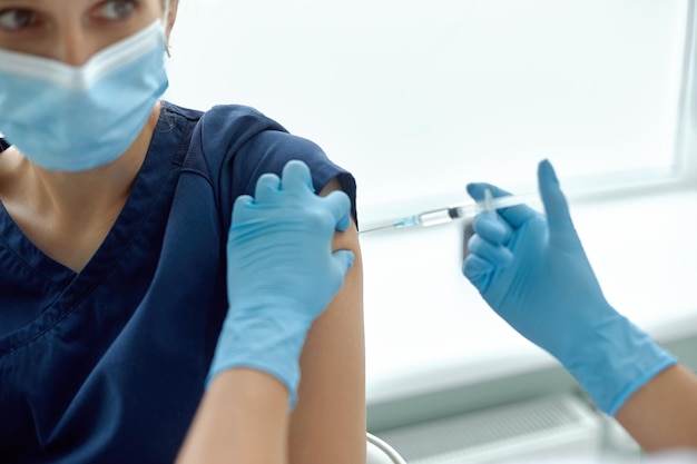 Foto vrouw in medische injectie krijgt in ziekenhuis dokter bereidt spuit voor om schot aan patiënt te geven