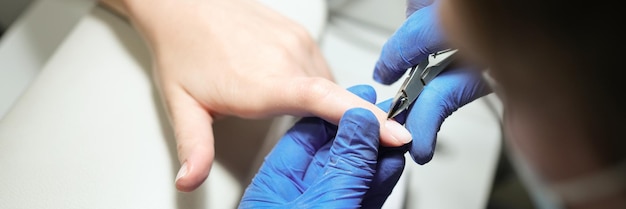 Foto vrouw in nagelsalon die manicure doet door schoonheidsspecialiste met nagelknipper vrouw die manicure krijgt