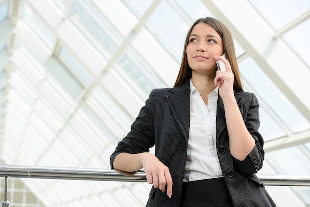 Vrouw in pak spreekt op telefoon