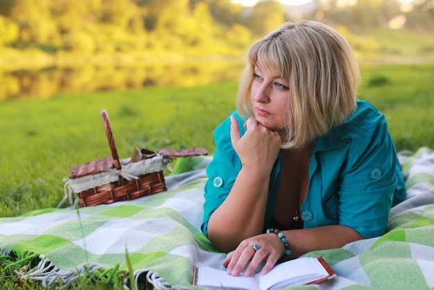 Vrouw in park met boek op het gras