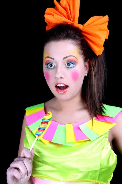 Vrouw in popstijl met creatieve make-up en lolly over zwart