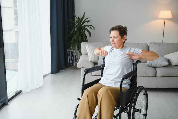 Vrouw in rolstoel aan het trainen in woonkamer