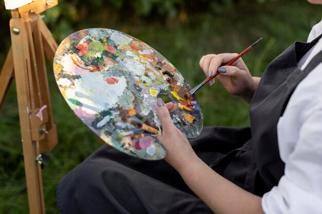 Vrouw in rolstoel buiten in de natuur schilderen op canvas