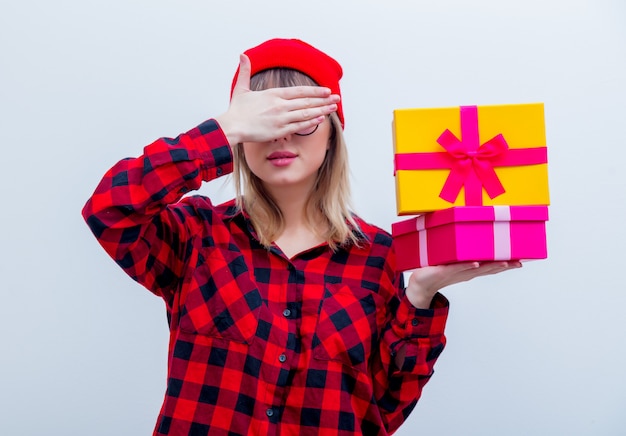 Foto vrouw in rood shirt en hoed bedrijf vakantie geschenkdozen