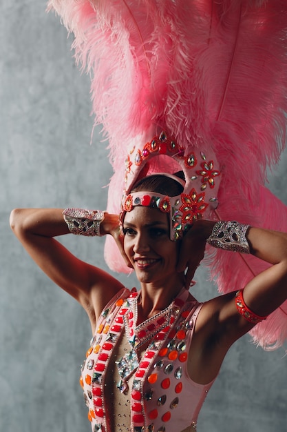 Vrouw in samba of lambada kostuum met roze veren verenkleed.