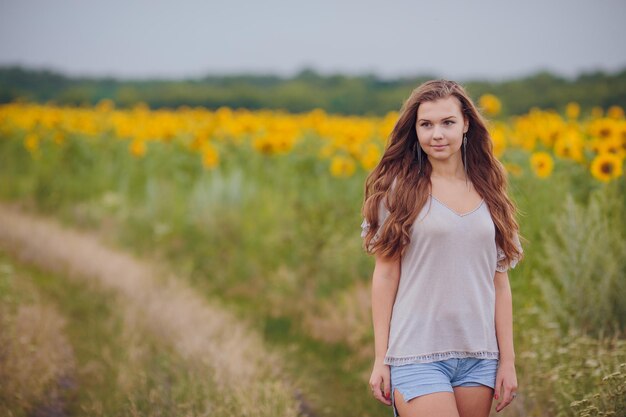 Vrouw in schoonheidsveld met zonnebloemen