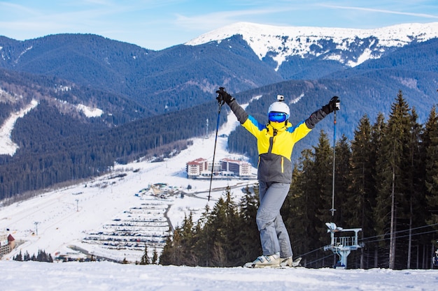 Vrouw in ski-uitrusting op de top van de heuvel. levensstijl