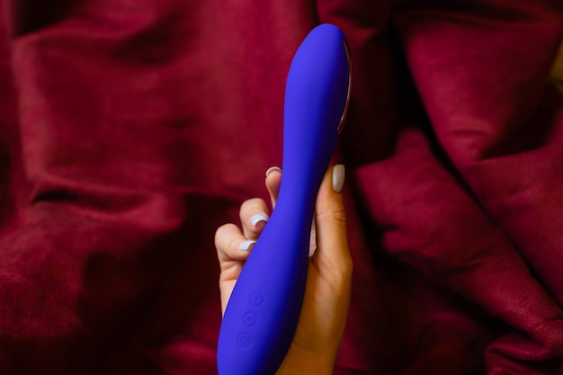 Vrouw in slaapkamer met vibrator in de hand