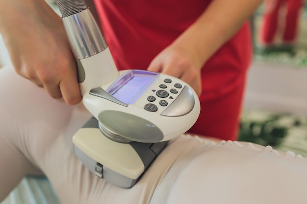 Vrouw in speciaal wit pak anticellulitis massage krijgen in een spa salon.