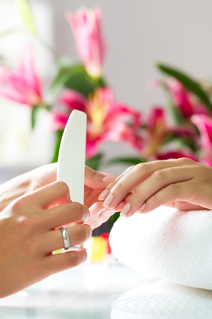 Foto vrouw in spijkersalon die manicure ontvangen