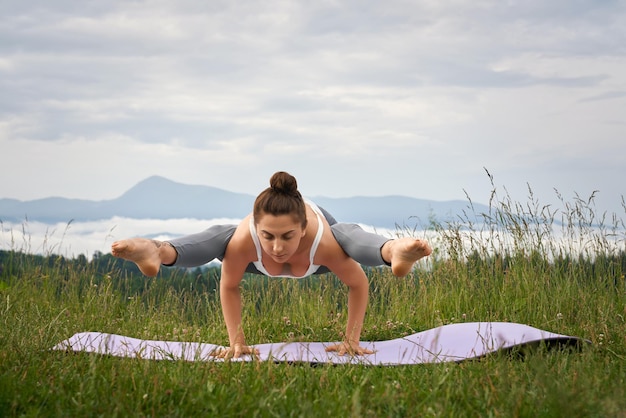 Vrouw in sportkleding die yogaoefening op verse lucht doet