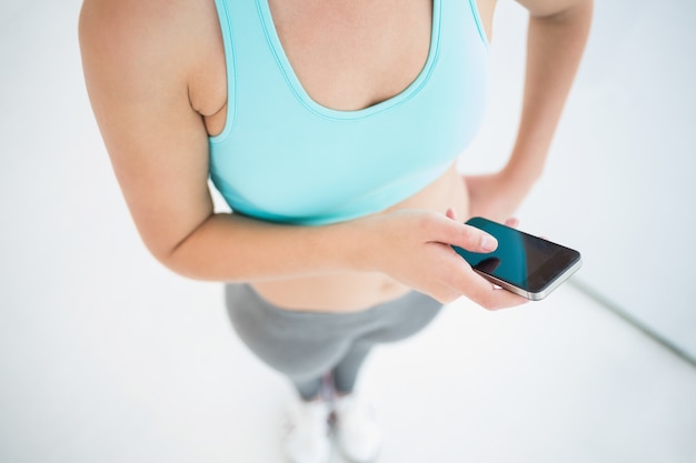 Foto vrouw in sportkleding met haar smartphone