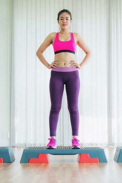 Vrouw in sportkleding praktijk yoga training die zich uitstrekt in binnen gymnasium.