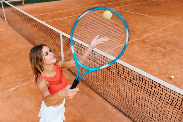 Vrouw in sportkleding speelt tennis bij competitie